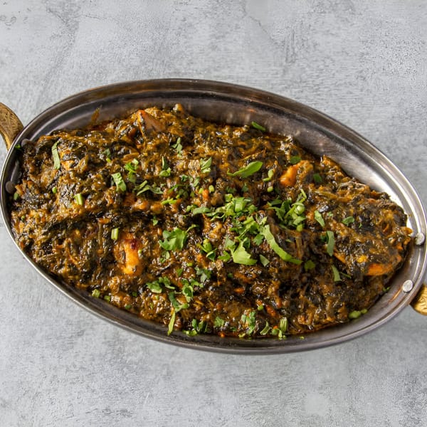 Palak chicken, an Indian dish with chicken in a thick spinach gravy, garnished with fresh cilantro.